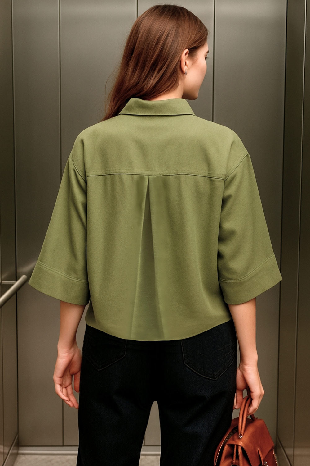 Camisa corta de fit oversized, manga 3/4 amplia con doblez en puños, cuello camisero, bolsillos frontales decorativos con cartera y pinza de amplitud en espalda. Cierre frontal con hilera de botones.