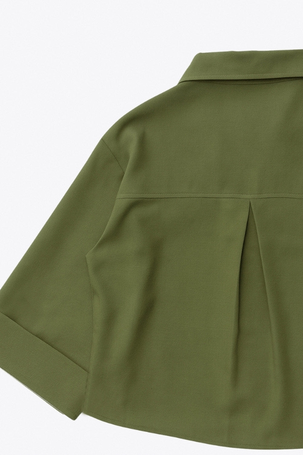 Camisa corta de fit oversized, manga 3/4 amplia con doblez en puños, cuello camisero, bolsillos frontales decorativos con cartera y pinza de amplitud en espalda. Cierre frontal con hilera de botones.