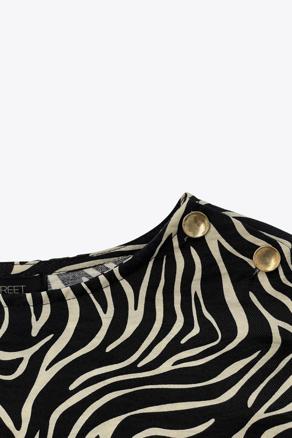 Blusa estampada de fit fluido, manga amplia 3/4, cuello barco y botones decorativos en hombro.