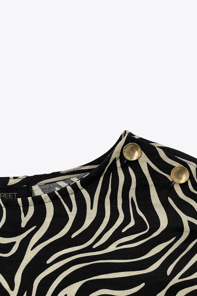 Blusa estampada de fit fluido, manga amplia 3/4, cuello barco y botones decorativos en hombro.