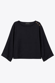 Blusa amplia de fit fluido, cuello redondo, manga larga con hombro caído y botones decorativos en hombro.