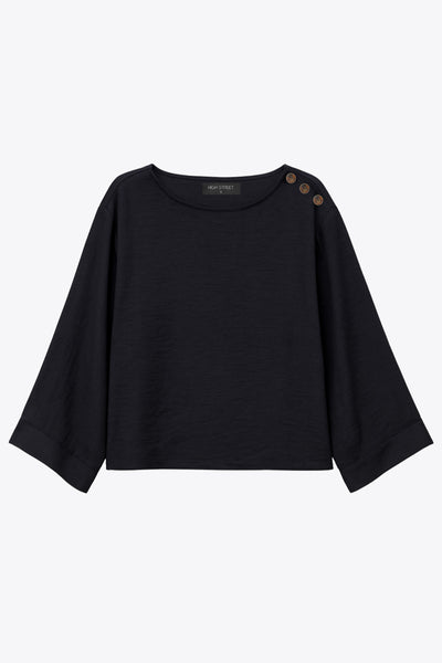 Blusa amplia de fit fluido, cuello redondo, manga larga con hombro caído y botones decorativos en hombro.