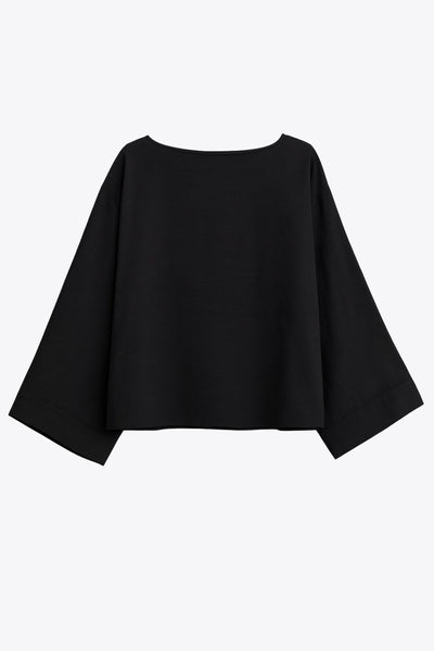 Blusa amplia de fit fluido, cuello redondo, manga larga con hombro caído y botones decorativos en hombro.