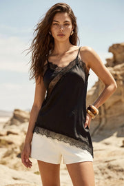 Blusa fluida larga de tirantes delgados ajustables, escote v con escote decorativo en contraste, cut out diagonal y bajo asimétrico frontal.