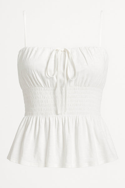 Blusa corta de tirantes delgados ajustables, escote recto con plisados y lazo ajustable frontal, fruncido en cintura y peplum de olanes en bajo.