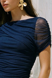 Blusa de mesh, fit ajustado, plisados en costados, cuello barco, detalle decorativo de capas con plisados y manga corta seguidos.