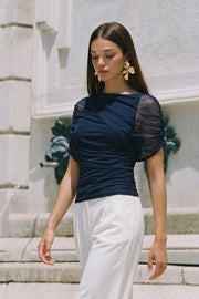 Blusa de mesh, fit ajustado, plisados en costados, cuello barco, detalle decorativo de capas con plisados y manga corta seguidos.