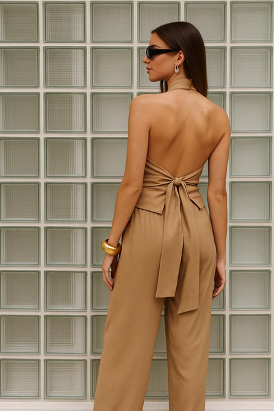 Blusa corta de fit recto, halter con cuello fluido, sin mangas, lazo amarrable en cintura, cierre posterior con botón y ojal.