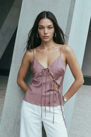 Blusa satinada de tirantes delgados ajustables, fit fluido, escote v con abertura frontal en diagonal, cut outs y lazos amarrables.