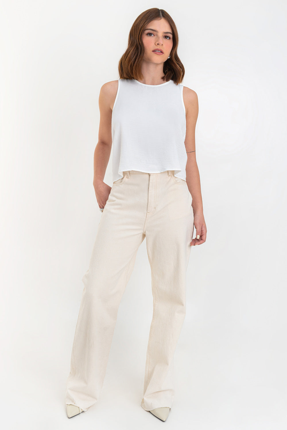 Blusa sin mangas de fit ligeramente oversized, cuello redondo y cierre posterior con botón y ojal.