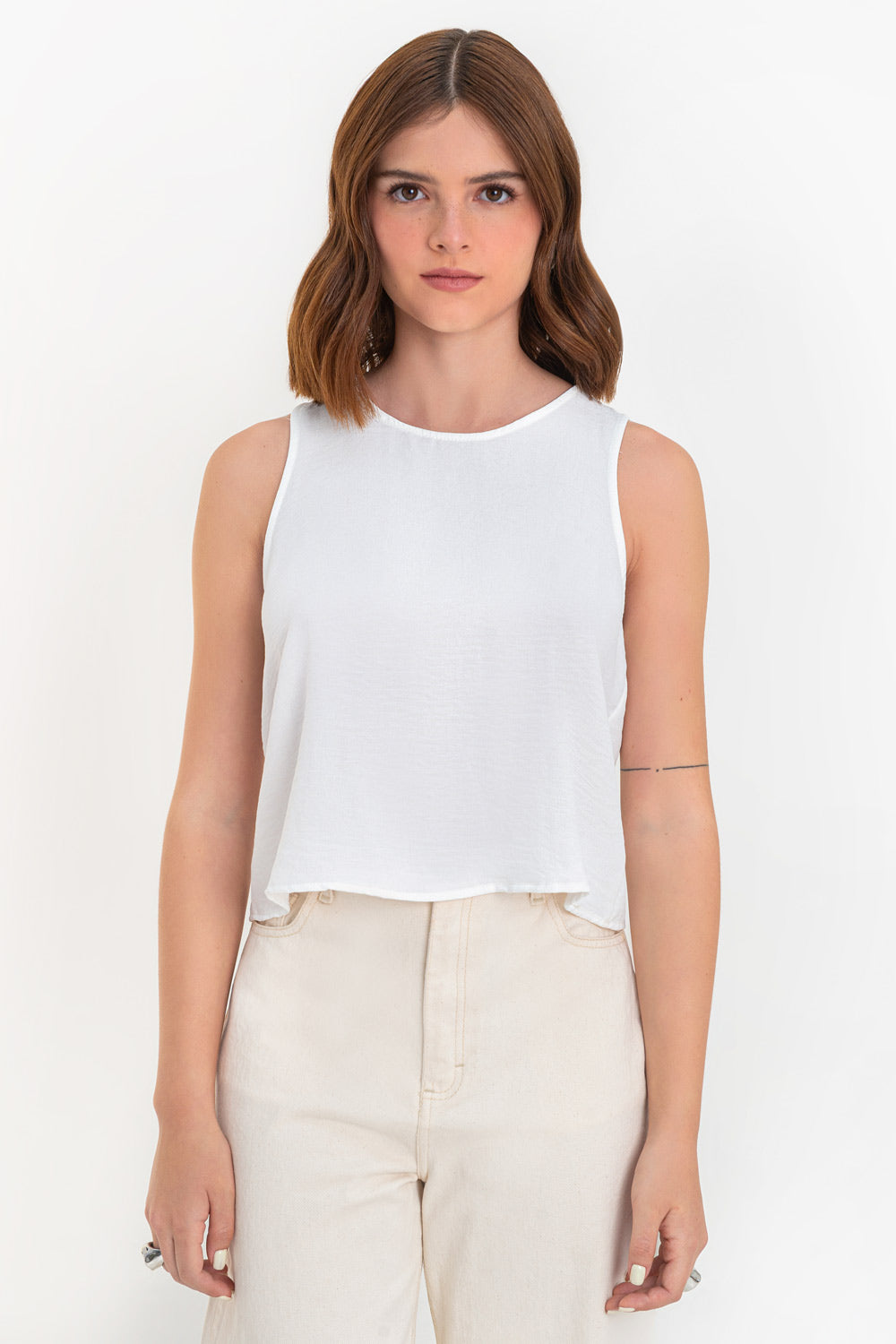 Blusa sin mangas de fit ligeramente oversized, cuello redondo y cierre posterior con botón y ojal.