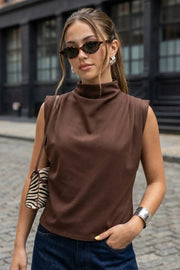 Blusa de fit oversized, sin mangas y cuello alto con detalles plisados en hombros.