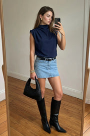 Blusa de fit oversized, sin mangas y cuello alto con detalles plisados en hombros.