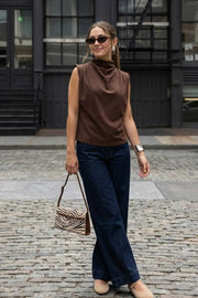 Blusa de fit oversized, sin mangas y cuello alto con detalles plisados en hombros.