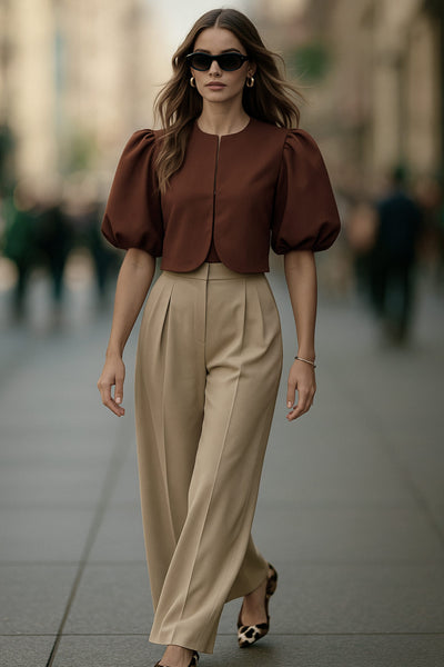 Blusa corta de fit recto, cuello redondo, manga corta amplia globo con volumen en borde, cierre frontal con broches ocultos y bajo curveado frontal.