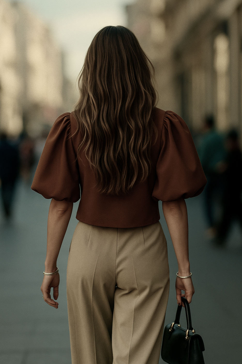 Blusa corta de fit recto, cuello redondo, manga corta amplia globo con volumen en borde, cierre frontal con broches ocultos y bajo curveado frontal.