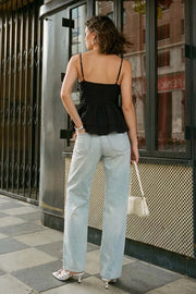 Blusa corta de tirantes delgados ajustables, escote v con olanes en borde, cortes frontales con plisados, peplum con olanes en bajo y cierre frontal con lazos amarrables.