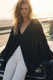 Blusa túnica de fit fluido, manga larga abullonada con puños, escote v &nbsp;y cierre frontal con hilera de botones.