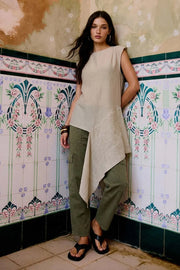 Blusa túnica de fit fluido, manga corta seguida, cuello redondo, detalle decorativo asimétrico en bajo lateral, cierre posterior con botón y ojal.