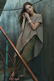 Blusa túnica de manga corta, cuello redondo, bajo lateral asimétrico y corte amplio.