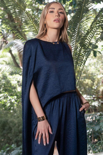 Blusa tipo túnica asimétrica, de cuello redondo, con hombreras, una manga corta seguida, fit fluido y bajo asimétrico.