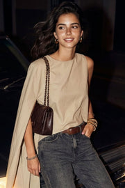Blusa tipo túnica asimétrica, de cuello redondo, con hombreras, una manga corta seguida, fit fluido y bajo asimétrico.