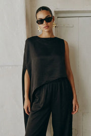 Blusa tipo túnica asimétrica, de cuello redondo, con hombreras, una manga corta seguida, fit fluido y bajo asimétrico.