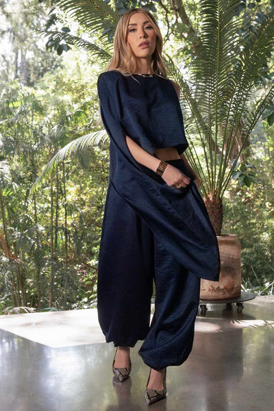 Blusa tipo túnica asimétrica, de cuello redondo, con hombreras, una manga corta seguida, fit fluido y bajo asimétrico.