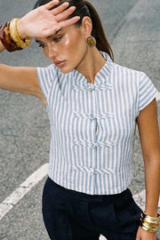Blusa corta de fit recto, estampado rayas, cuello mao, manga corta y cierre frontal con botones alamares.