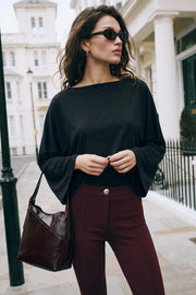 Blusa de fit fluido, manga larga amplia seguida y cuello barco.