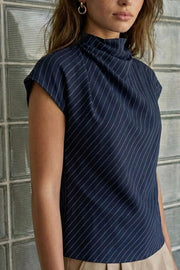 Blusa de estampado rayas, cuello alto fluido, plisados en hombros, manga corta seguida y fit recto. Cierre posterior con botón y ojal.