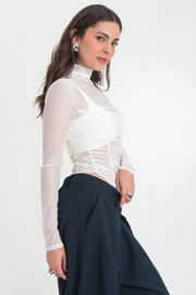 Body de mesh, fit ajustado, cuello alto con plisados, manga larga, corte alto en pierna y plisados decorativos en talle.