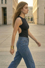 Body de fit ajustado, sin mangas, cuello redondo, plisados en costados y cut out en espalda con nudo decorativo posterior.