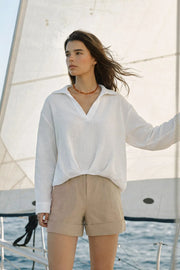 Camisa de fit fluido, manga larga con puño abotonado, cuello camisero, escote v y nudo decorativo en bajo. Detalle de textura en tejido, bajo curveado y pinza de amplitud en espalda.