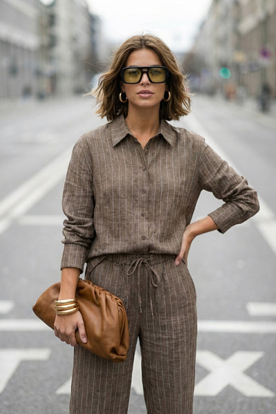 Camisa de rayas, ligeramente oversized, cuello camisero, manga larga con puño abotonado. Cierre frontal con hilera de botones.
