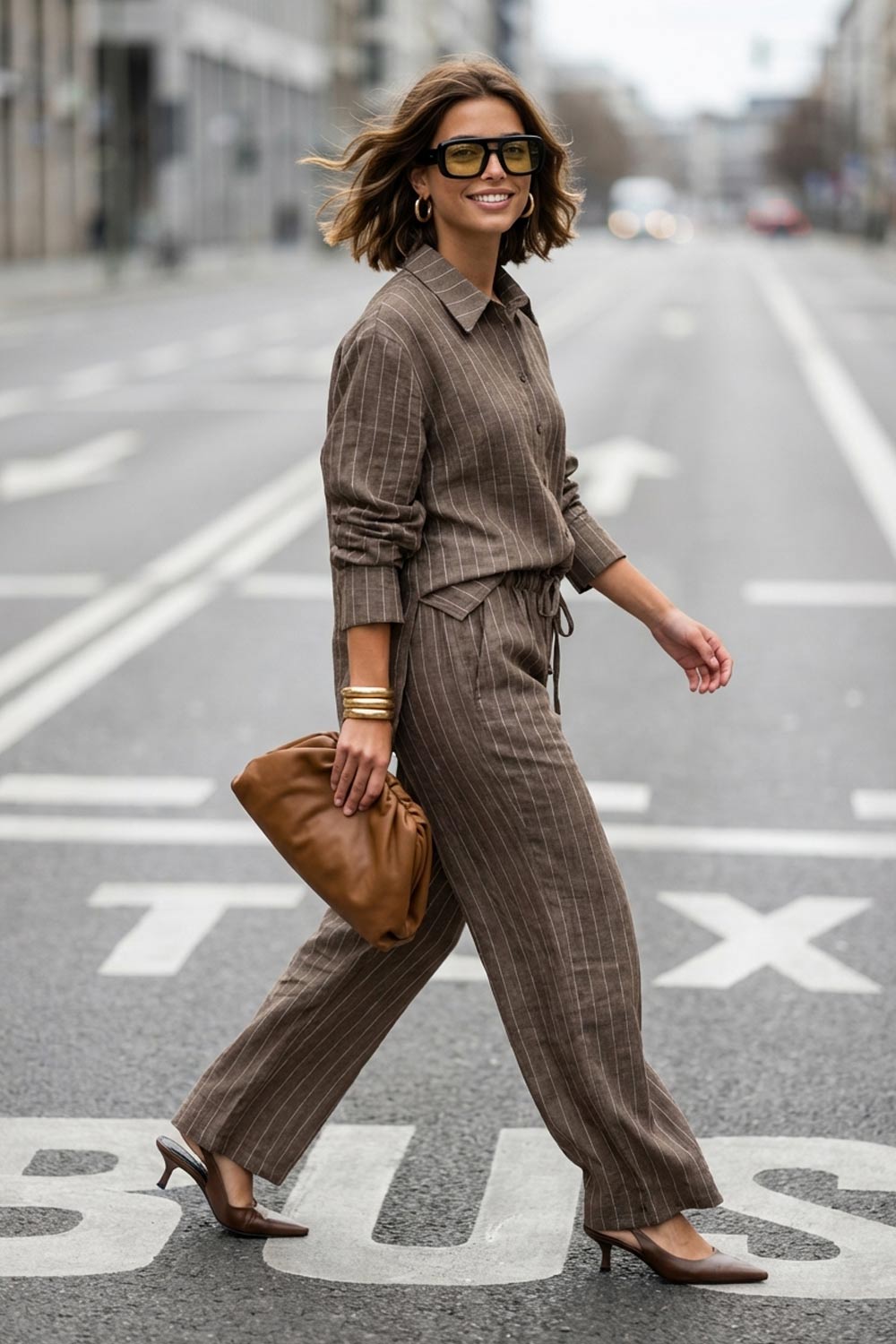 Camisa de rayas, ligeramente oversized, cuello camisero, manga larga con puño abotonado. Cierre frontal con hilera de botones.