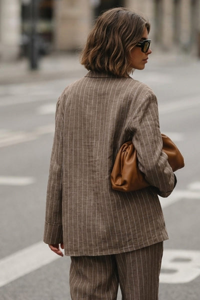 Camisa de rayas, ligeramente oversized, cuello camisero, manga larga con puño abotonado. Cierre frontal con hilera de botones.