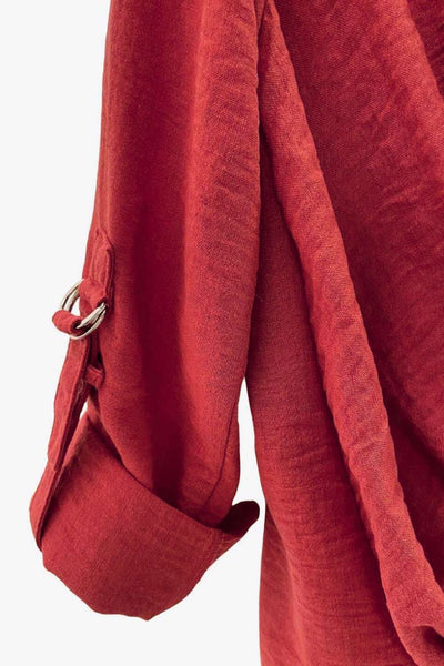 Camisa corta de fit recto, manga larga rolled up con trabilla ajustable, cuello camisero, cruce frontal con escote v y nudo decorativo en bajo. Detalle de bajo curveado y pinza de amplitud en espalda.