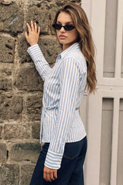 Camisa cruzada de estampado rayas, escote v, fit recto, manga larga con puño abotonado, cuello camisero, pinzas en espalda y cierre lateral con botón.