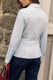 Camisa cruzada de estampado rayas, escote v, fit recto, manga larga con puño abotonado, cuello camisero, pinzas en espalda y cierre lateral con botón.