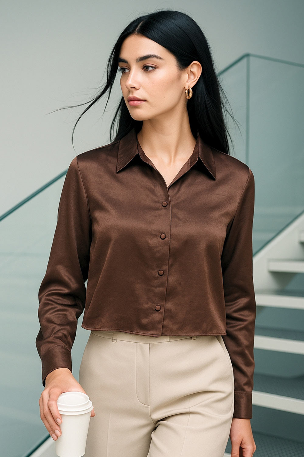 Camisa corta satinada de fit recto, cuello camisero, manga larga con puño abotonado, pinza de amplitud en espalda y cierre frontal con hilera de botones.