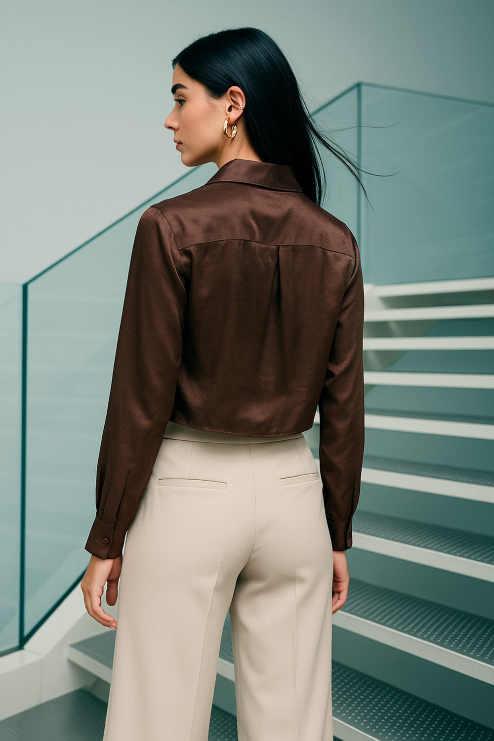 Camisa corta satinada de fit recto, cuello camisero, manga larga con puño abotonado, pinza de amplitud en espalda y cierre frontal con hilera de botones.