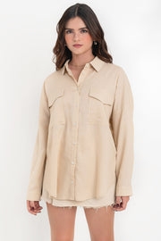 Camisa de lino, fit oversized, cuello camisero, manga larga con puño abotonado y trabillas ajustables, bolsillos frontales de parche con cartera y bajo curveado. Cierre frontal con hilera de botones.