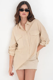 Camisa de lino, fit oversized, cuello camisero, manga larga con puño abotonado y trabillas ajustables, bolsillos frontales de parche con cartera y bajo curveado. Cierre frontal con hilera de botones.