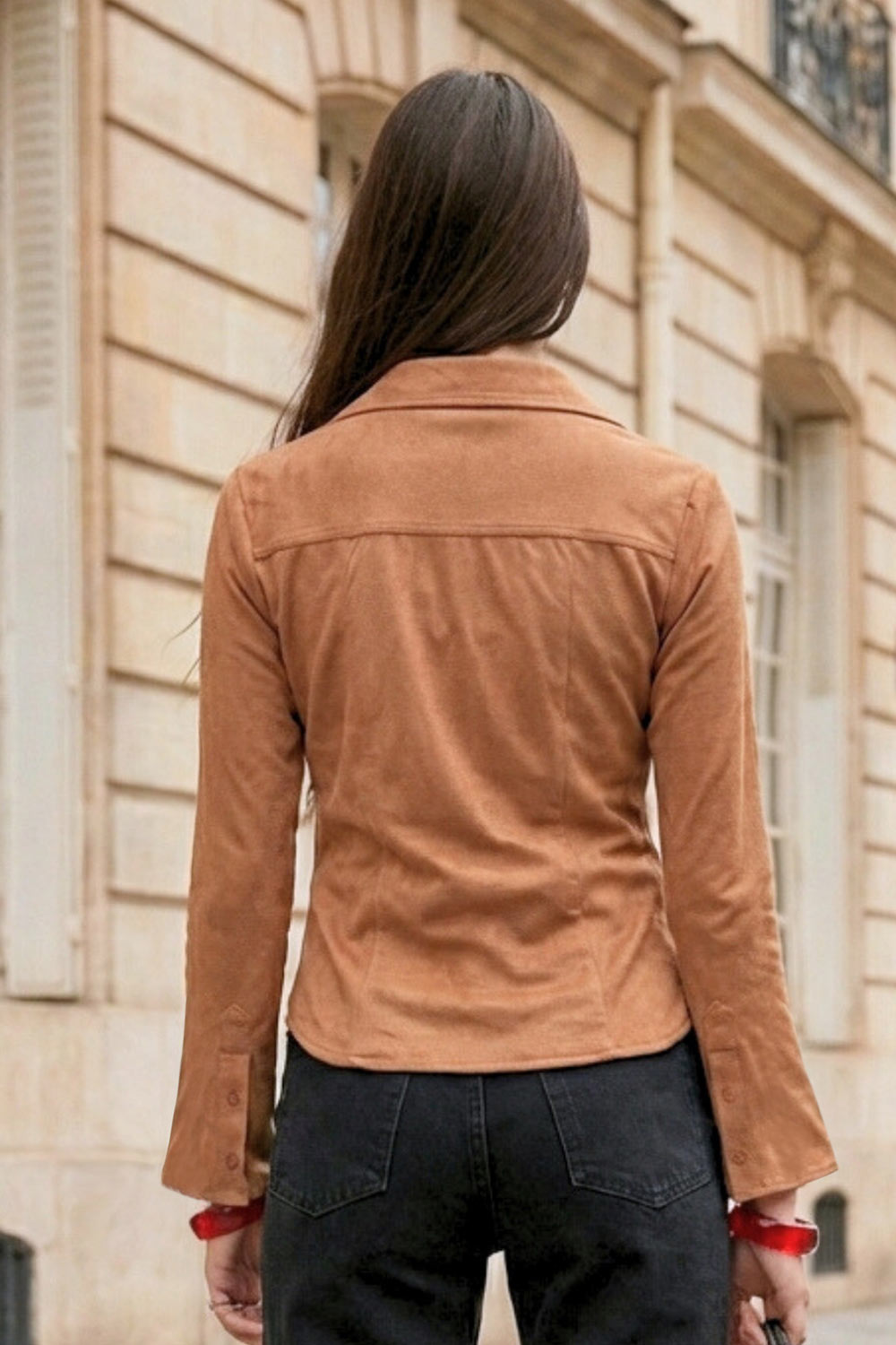 Camisa ajustada de gamuza, pinzas frontales, cuello camisero, bajo curveado, manga larga con amplitud y puño abotonado. Cierre frontal con hilera de botones.