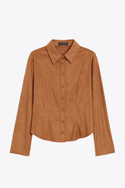 Camisa ajustada de gamuza, pinzas frontales, cuello camisero, bajo curveado, manga larga con amplitud y puño abotonado. Cierre frontal con hilera de botones.