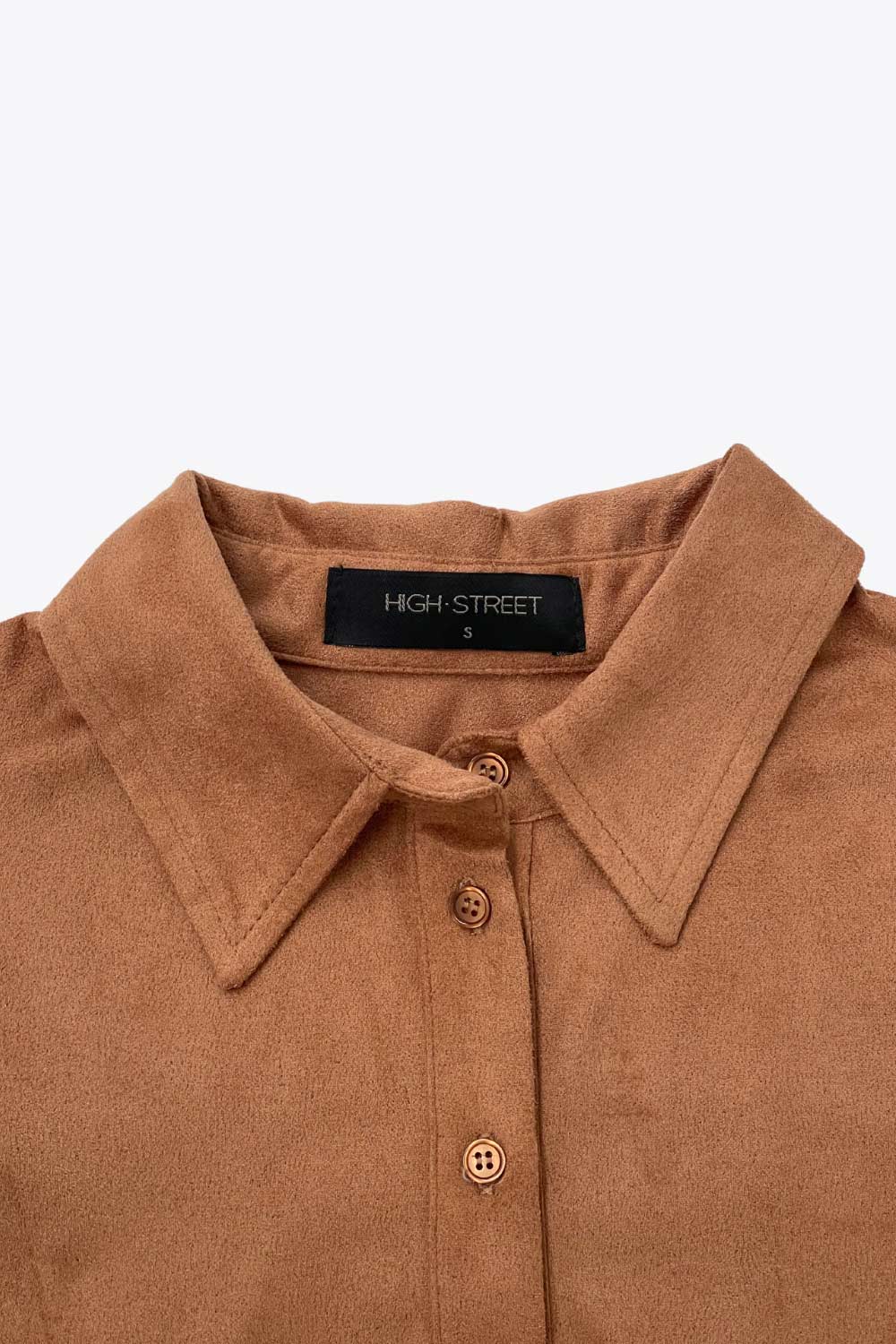 Camisa ajustada de gamuza, pinzas frontales, cuello camisero, bajo curveado, manga larga con amplitud y puño abotonado. Cierre frontal con hilera de botones.