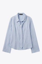 Camisa de fit ajustado, estampado rayas, cuello camisero, manga larga con puño amplio abotonado, pinzas, bajo curveado y cierre frontal con hilera de botones. Detalle de corbata del mismo tejido.