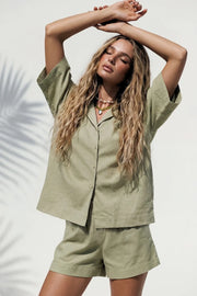 Camisa de lino, fit oversized, manga corta amplia, cuello solapa, pinza de amplitud en espalda y aberturas laterales en bajo. Cierre frontal con hilera de botones.