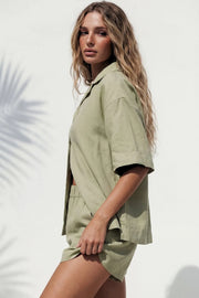 Camisa de lino, fit oversized, manga corta amplia, cuello solapa, pinza de amplitud en espalda y aberturas laterales en bajo. Cierre frontal con hilera de botones.